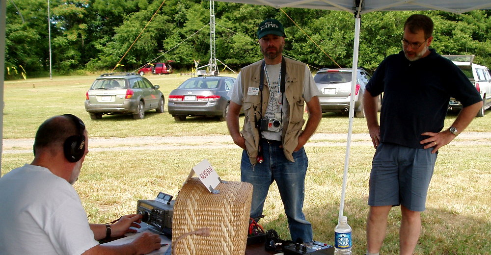 So What's Going On Here ?
Too Many Stations Just Didn't Copy Us Plus We Had That Hash From 20-Meters CW! - Buddy Brewer - K4CJB tries while Kurt Reber - KI4FWB and Rick Denny - KR9D look on. Photograph by Norm Styer - AI2C de Clarkes Gap, VA.