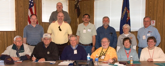 Group photograph of the VE Team who administered 28 tests on 4 April 2009 at the Leesburg, VA VFW Post. SITTING (left to right) Ray Johnson K5RJ, Terry Hines N4ZH, Arthur Laurent KD4CSO, Alan Moeck WA2RPX, Gloria Borgrink KE4JEH, Lisa Thevenet KD4DGO. STANDING (left to right) Bob Kemner K4RWK, LTC Jay R. Greeley KI4UTB, VE Team Leader Jorge Thevenet KD4DGQ, standing behind LTC Greeley, Luther Guise K4NOB, Chuck Borgrink W4LFO, Carol Boehler KF4TJJ, and Jay Ives KI4TXP. Missing from the photograph is Larry Hughes K3HE.